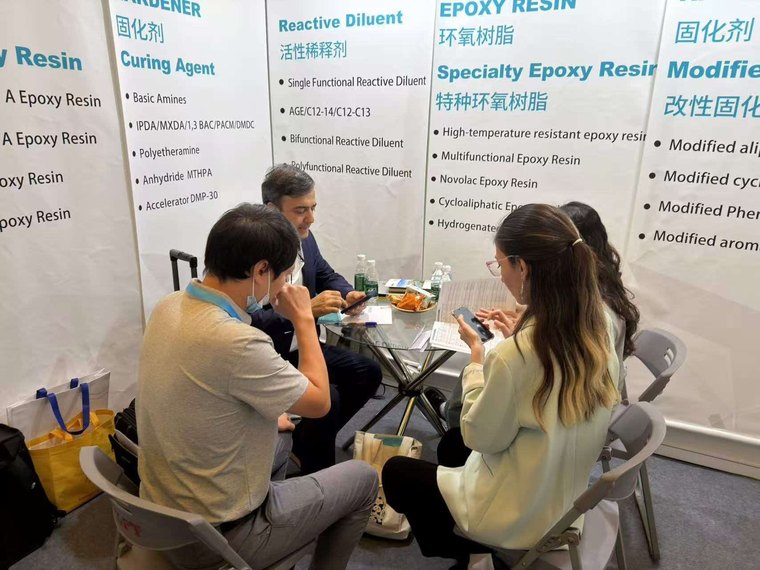 Yolatech staff discussing epoxy resin and curing agent specifications with a visitor at ASE CHINA 2026